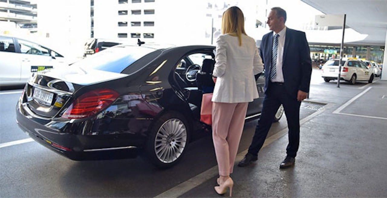 Premium St. Louis airport limo service featuring a professional chauffeur and luxury black car curbside pickup at St. Louis Lambert International (STL).