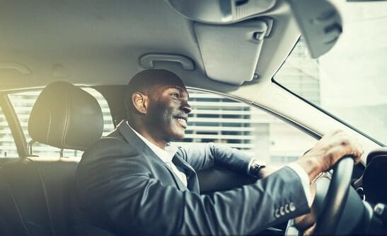 np_Happy man in business attire driving luxury vehicle_5Q1oe5_free Point To Point Chauffeur