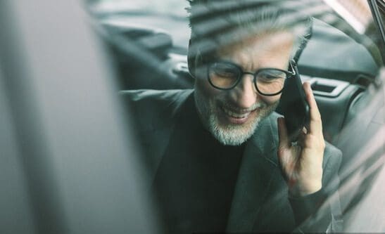np_Smiling mature businessman talking on the cell phone while sitting on back seat of a taxi_0vq2pb_free Business Traveler
