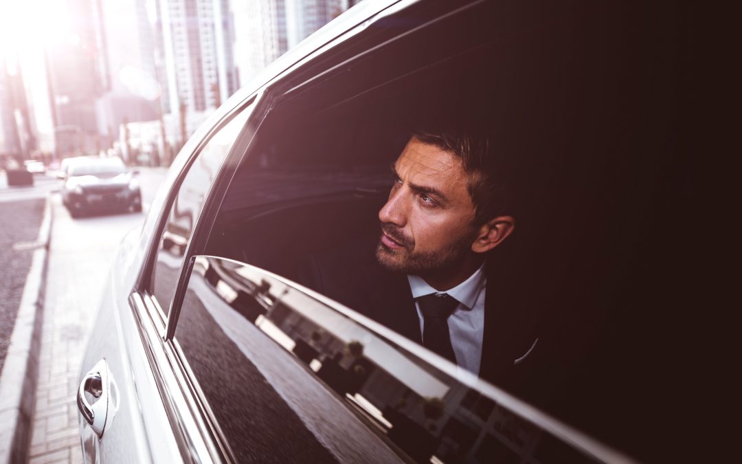 A professional businessman in a suit looking out the window of a luxury black car, illustrating Gateway Limousine’s executive chauffeur services and airport transfers in St. Louis.